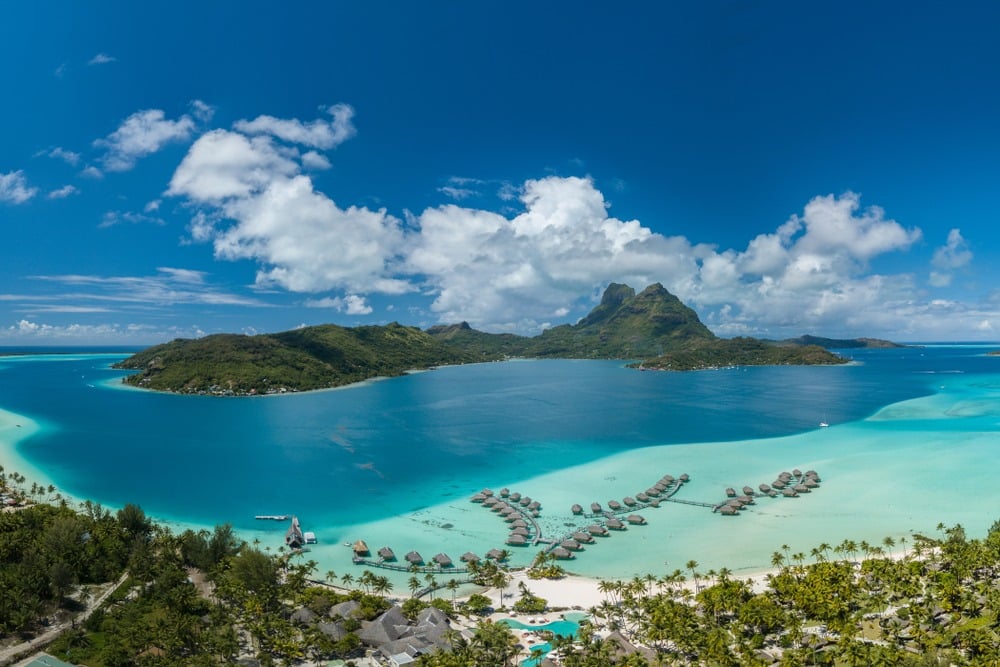 Panoramic,Aerial,View,Of,Luxury,Overwater,Villas,With,Palm,Trees,